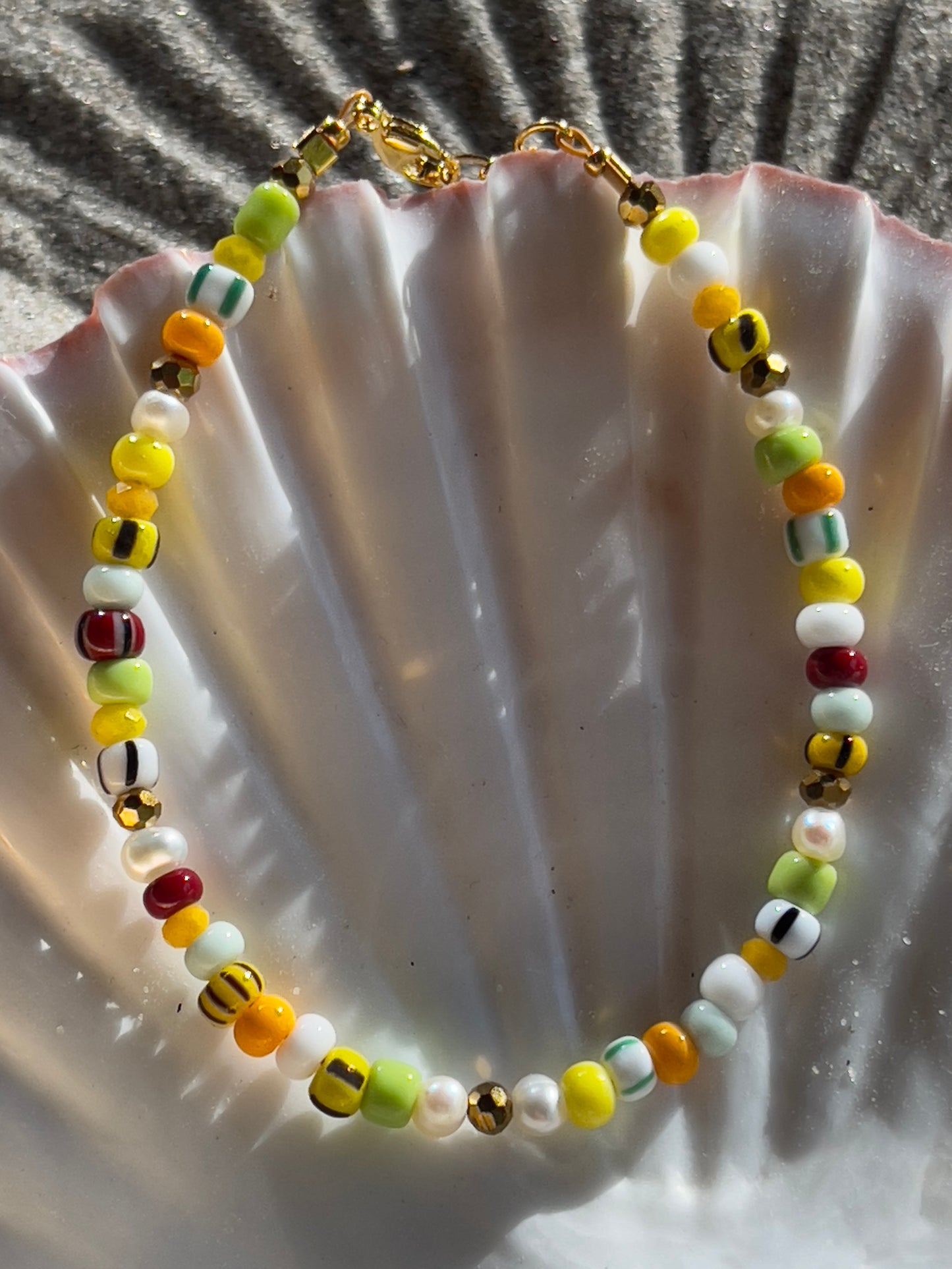 Armbånd med store Seed Beads i lækre gulegrønne, orange og brune nuancer og med små ferskvandsperler