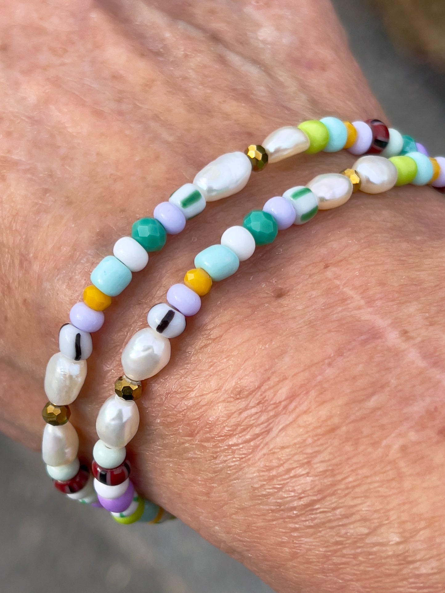 Armbånd med store Seed Beads i lækre lilla og grønne nuancer og med små ferskvandsperler