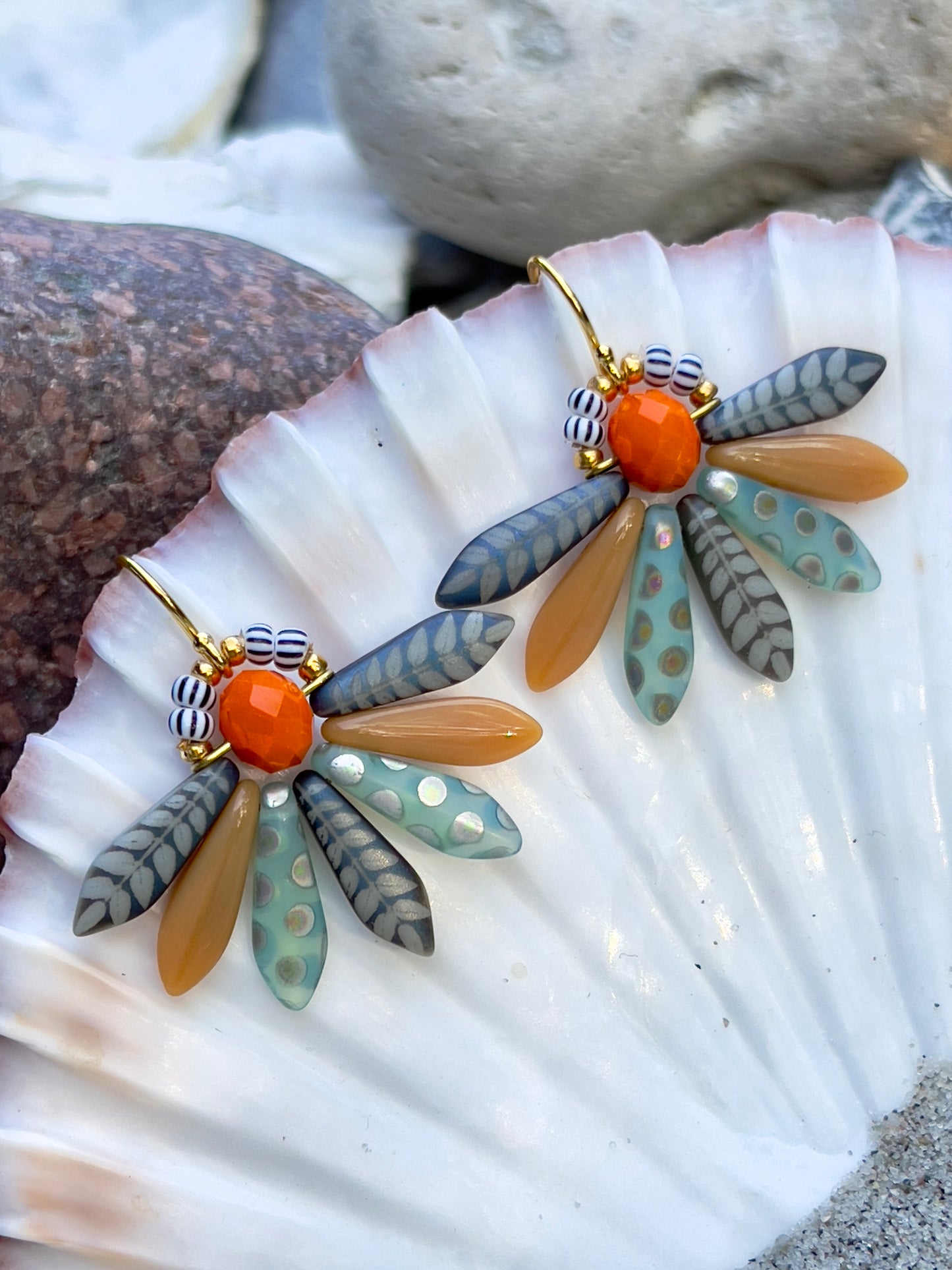 Speciel blomsterørering i blå nuancer med orange glasperle