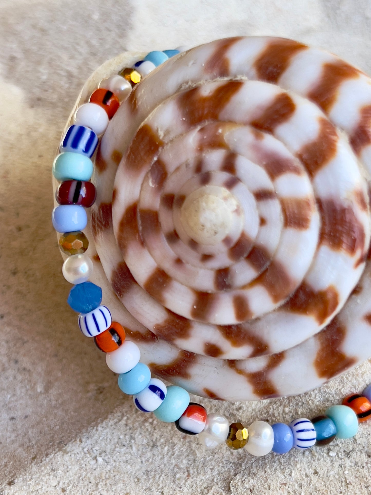 Armbånd med store Seed Beads i dejlige orange, brune og blå nuancer og med små ferskvandsperler
