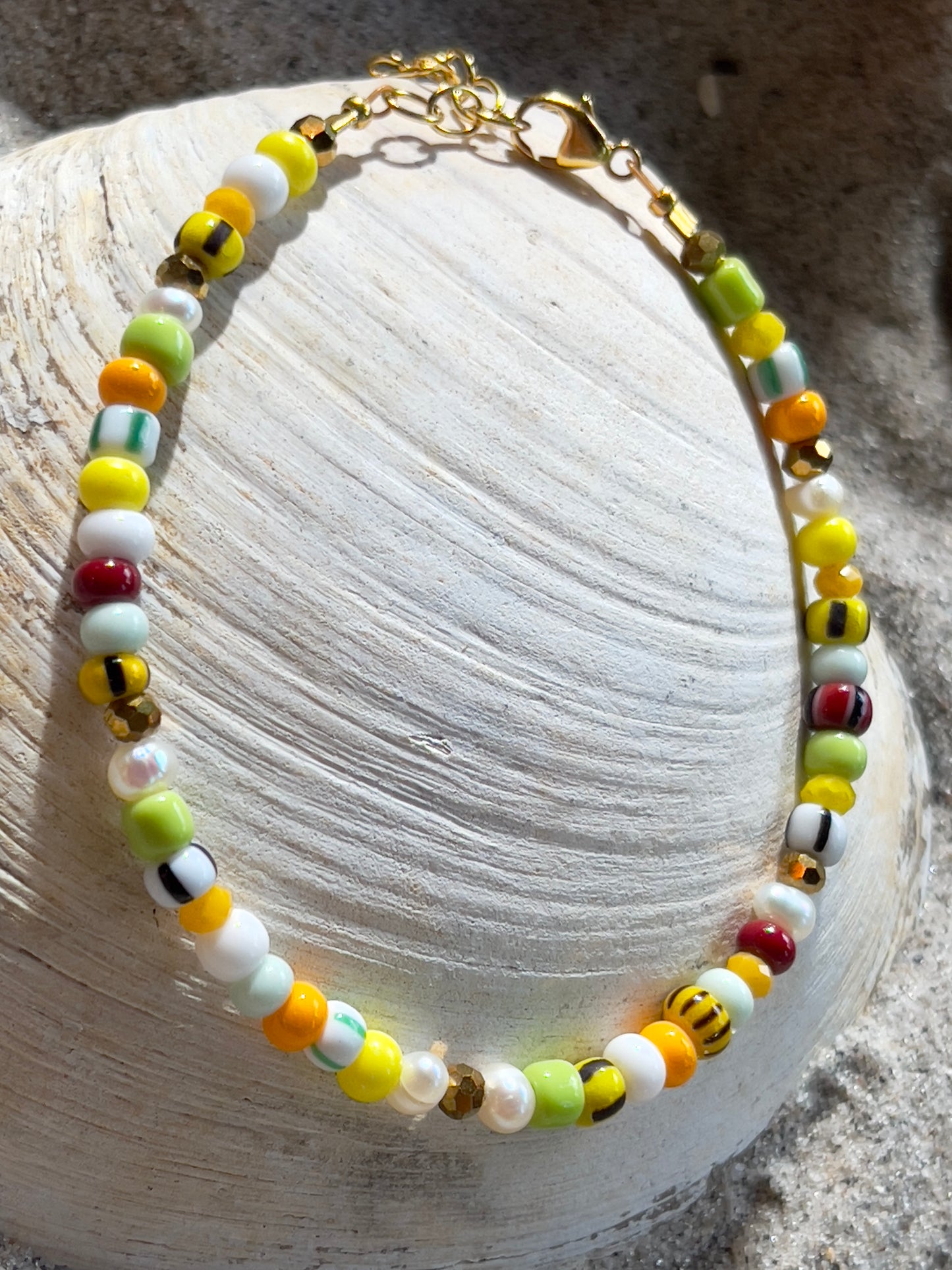 Armbånd med store Seed Beads i lækre gulegrønne, orange og brune nuancer og med små ferskvandsperler