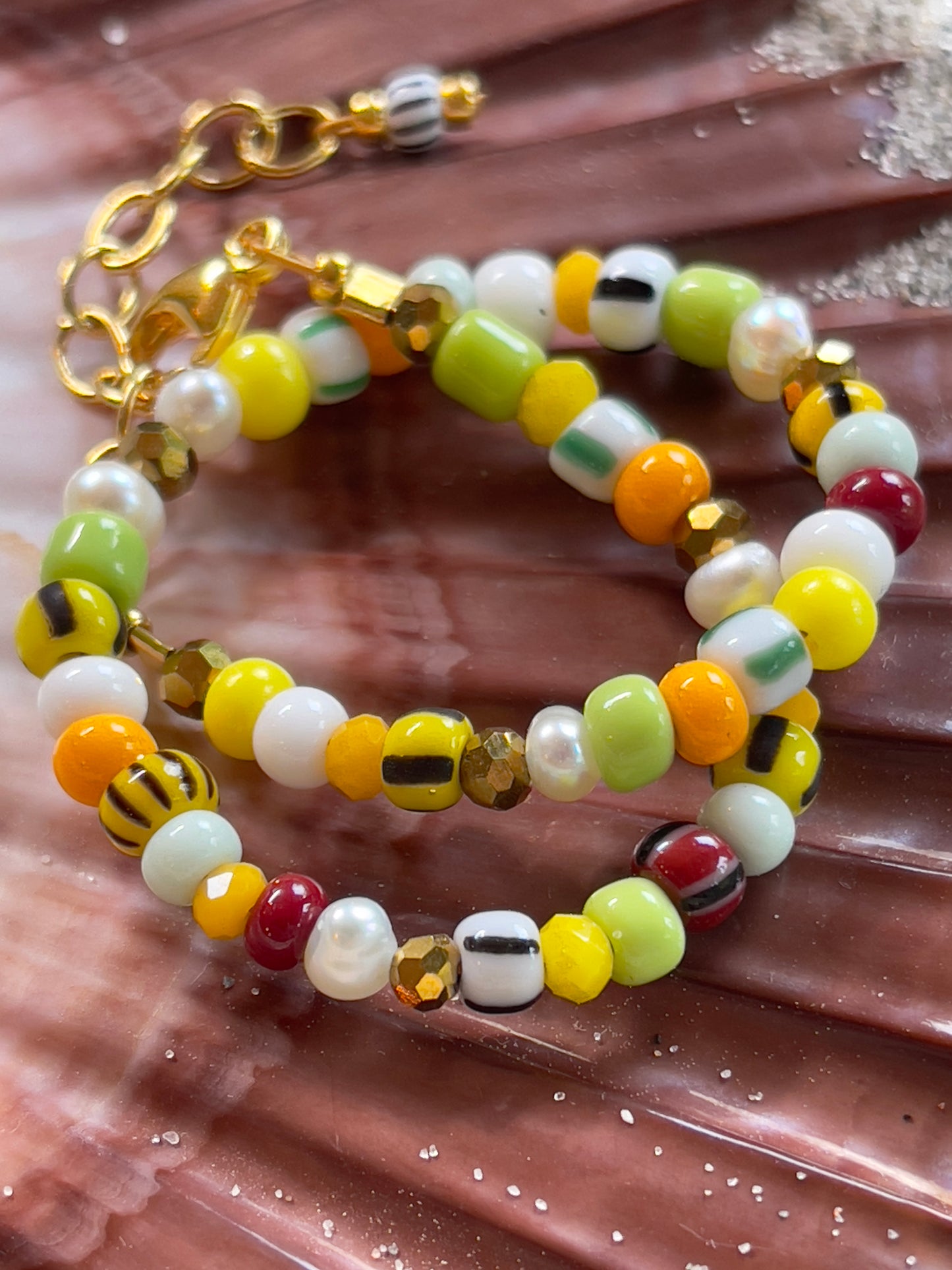 Armbånd med store Seed Beads i lækre gulegrønne, orange og brune nuancer og med små ferskvandsperler