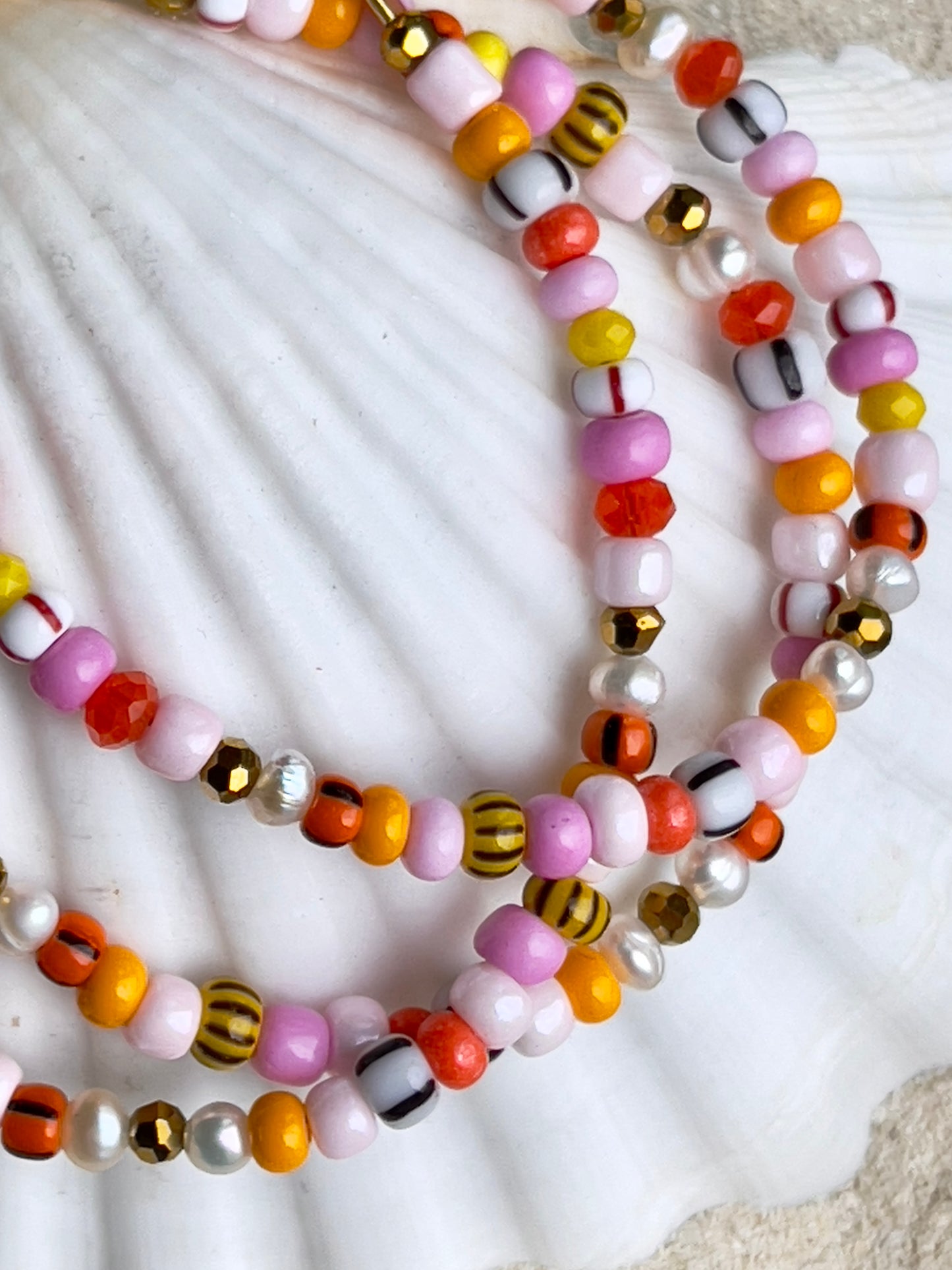 Armbånd med store Seed Beads i lækre rosa og orange farver og små ferskvandsperler