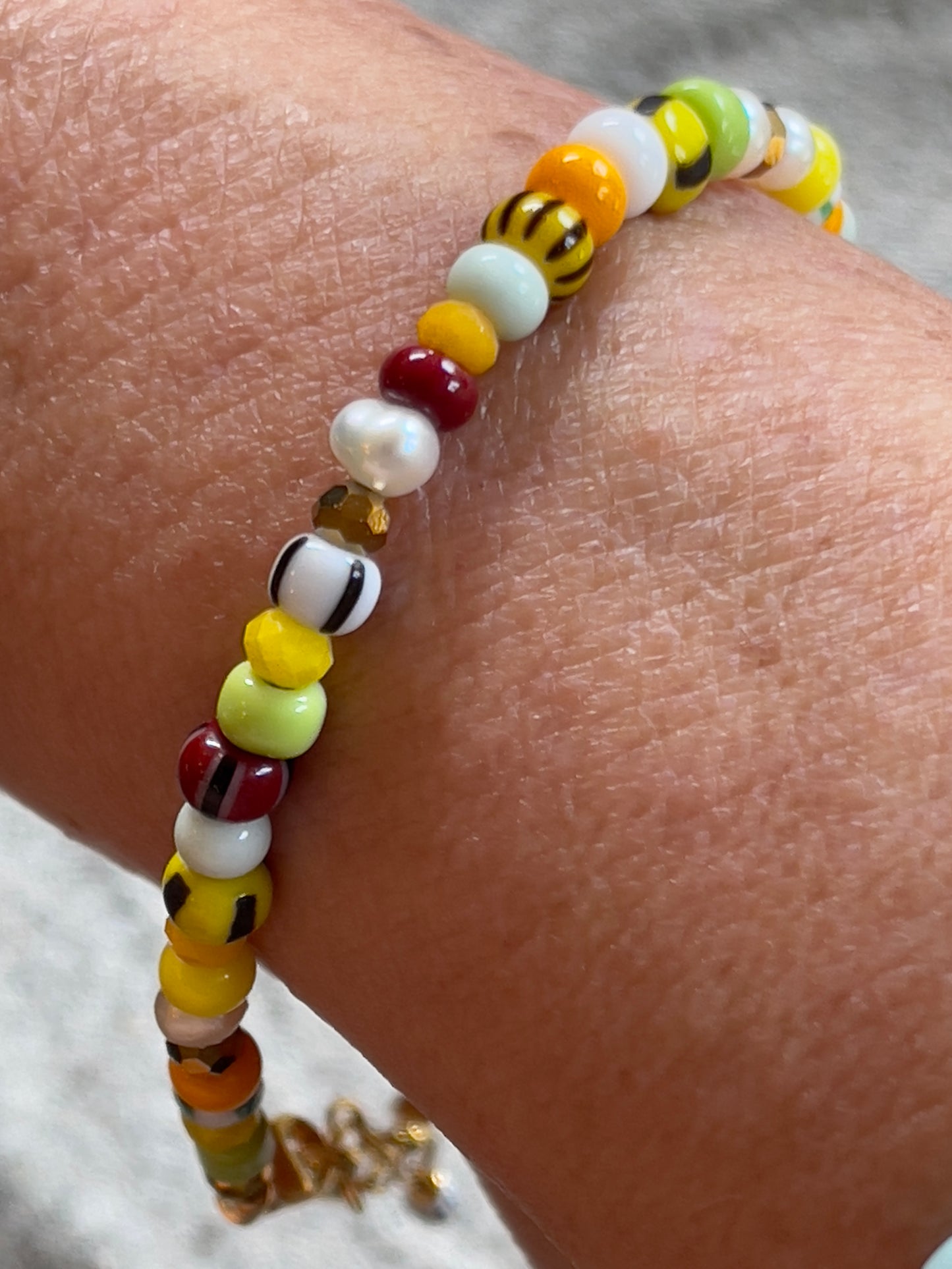 Armbånd med store Seed Beads i lækre gulegrønne, orange og brune nuancer og med små ferskvandsperler