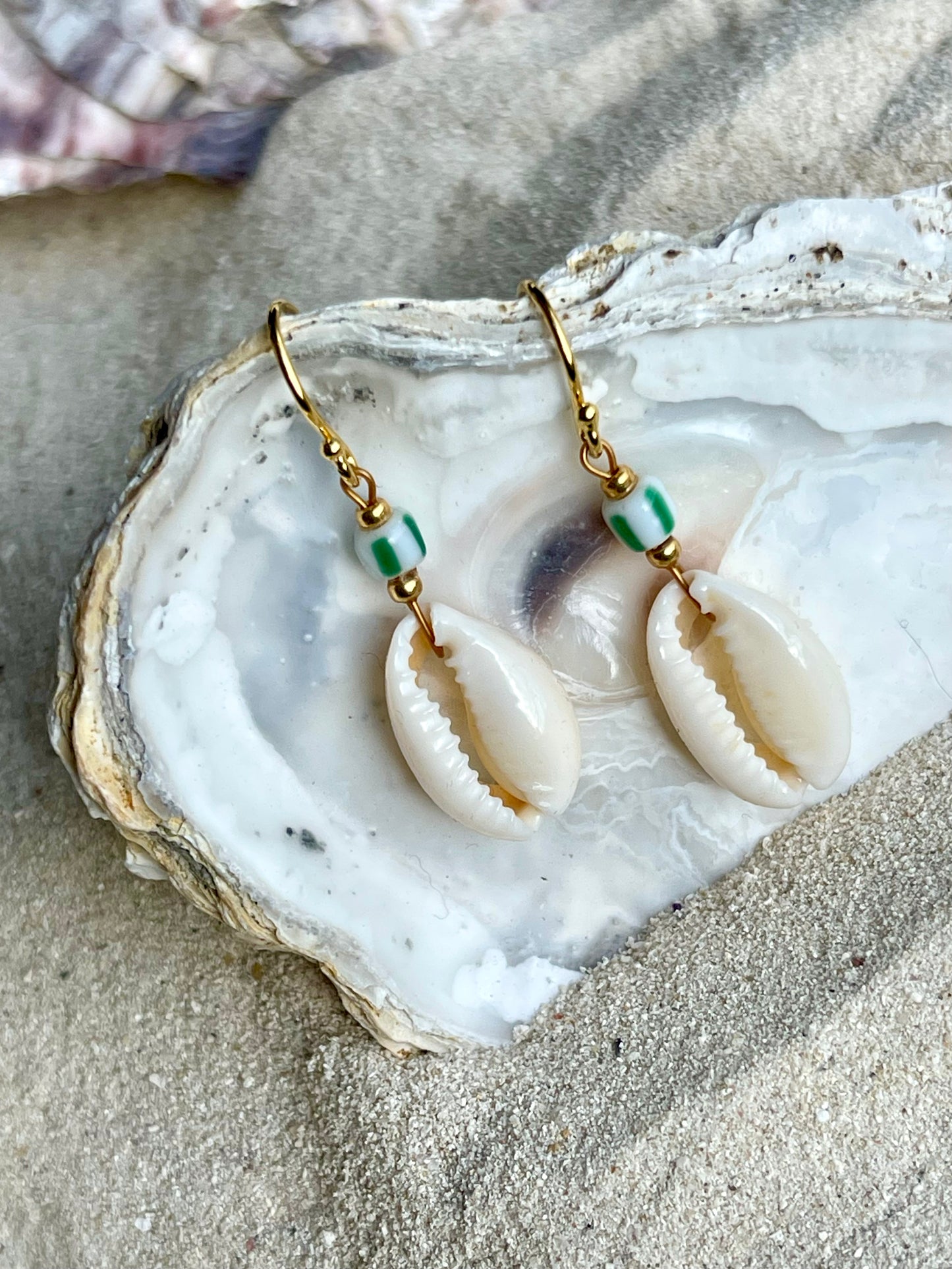 Delikat ørering med Cowrie Shell bead