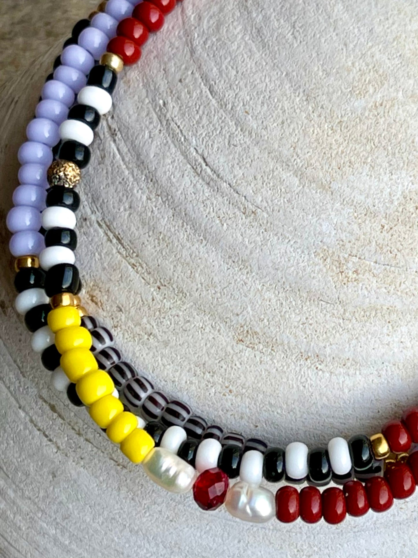 Armbånd med gul, rød og lilla seedbeads