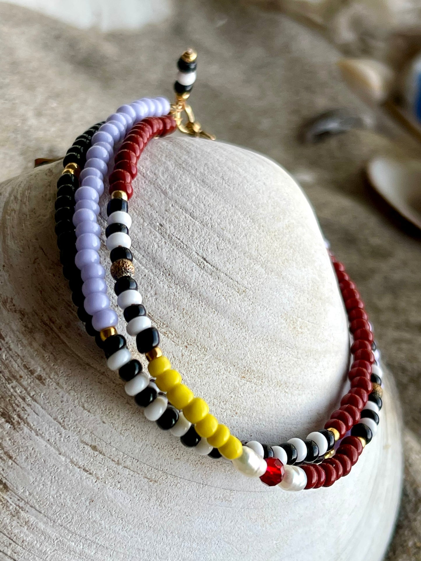 Armbånd med gul, rød og lilla seedbeads