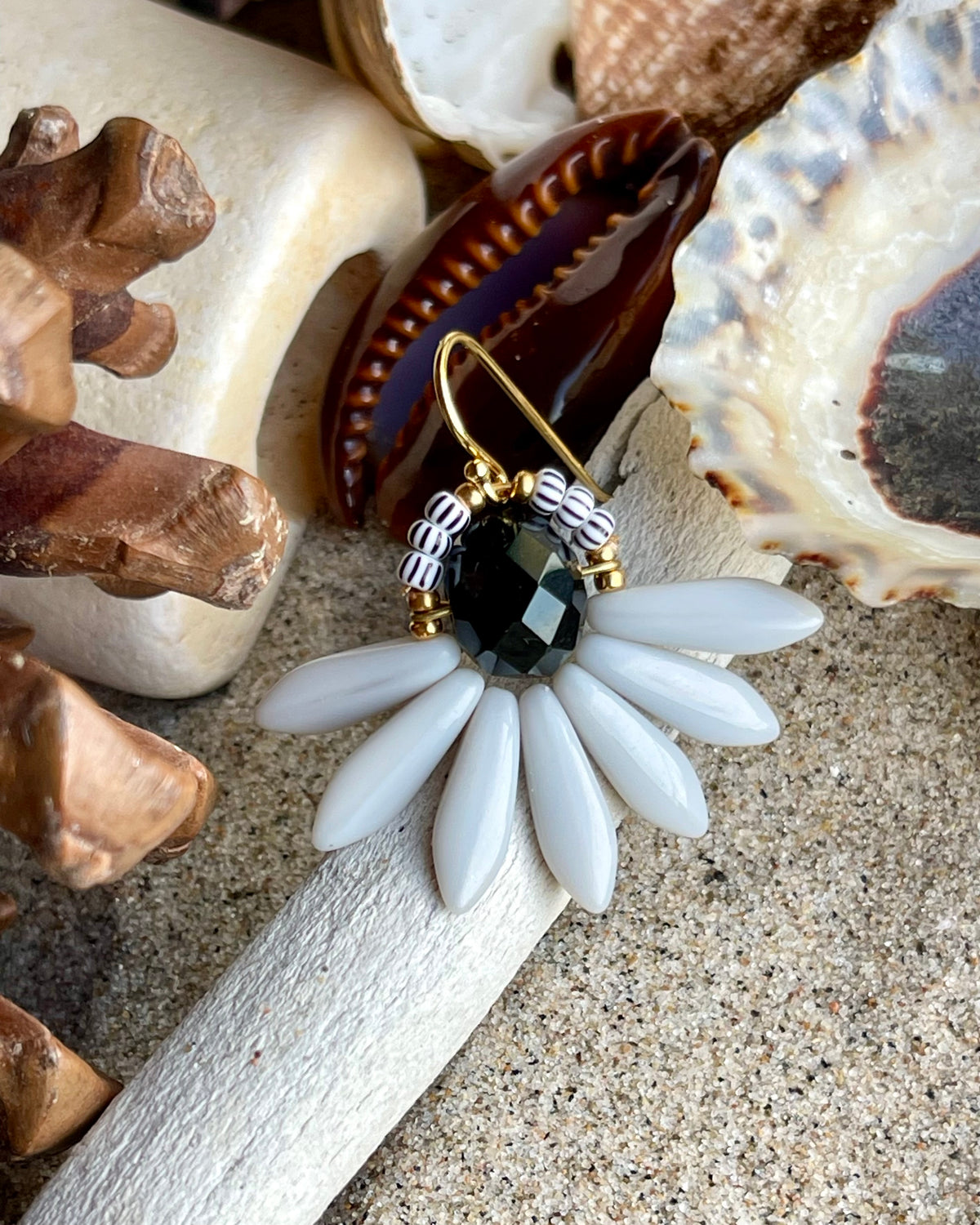 Stor blomsterørering med sort glasperle i midten og fine lysegrå glasperler som blade.