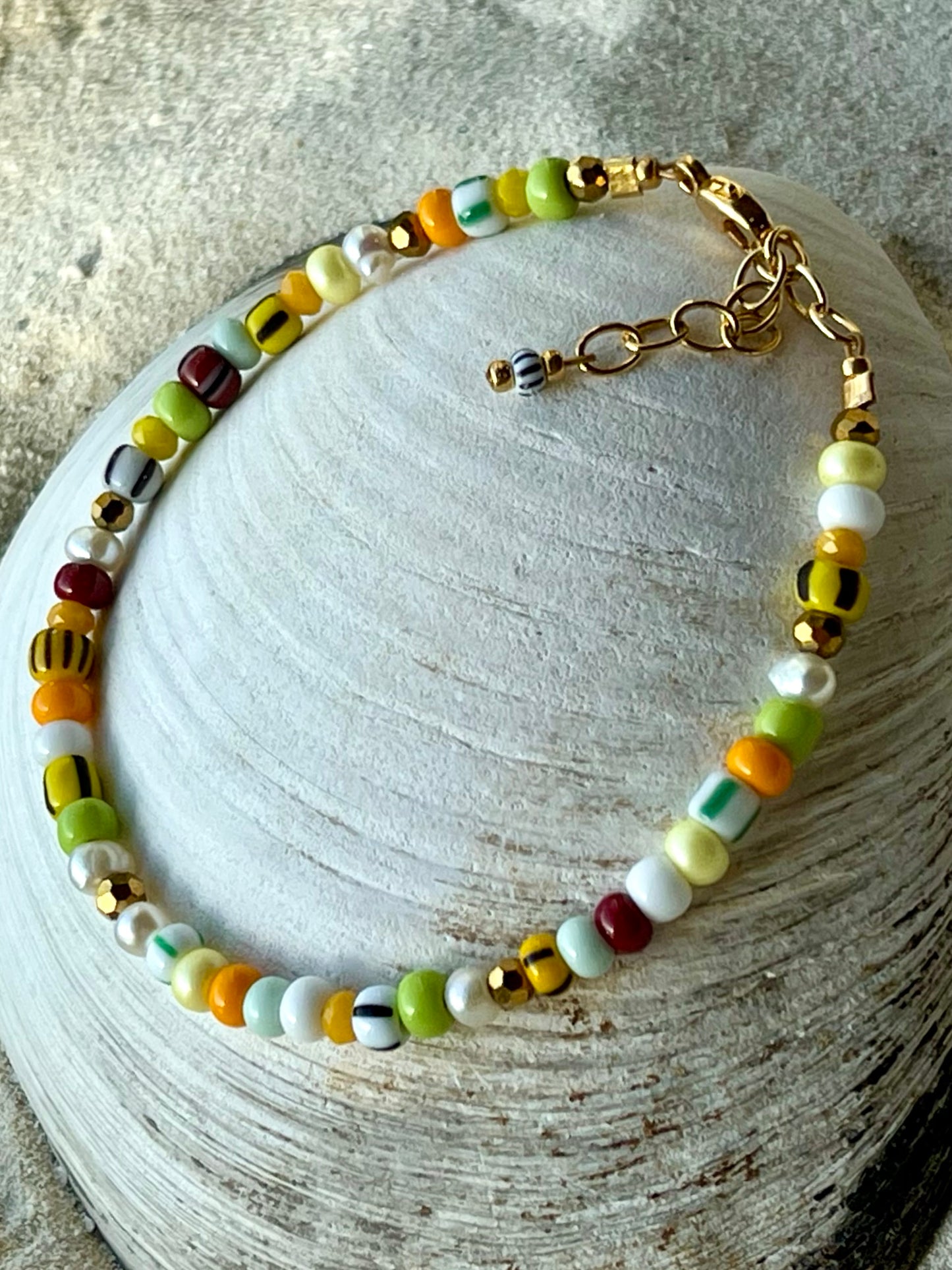 Armbånd med store Seed Beads i lækre gulegrønne, orange og brune nuancer og med små ferskvandsperler