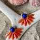Stor blomsterørering med blade af glasperler ibrændt orange og en flot koboltfarvet glasperle i midten.