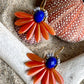 Stor blomsterørering med blade af glasperler ibrændt orange og en flot koboltfarvet glasperle i midten.