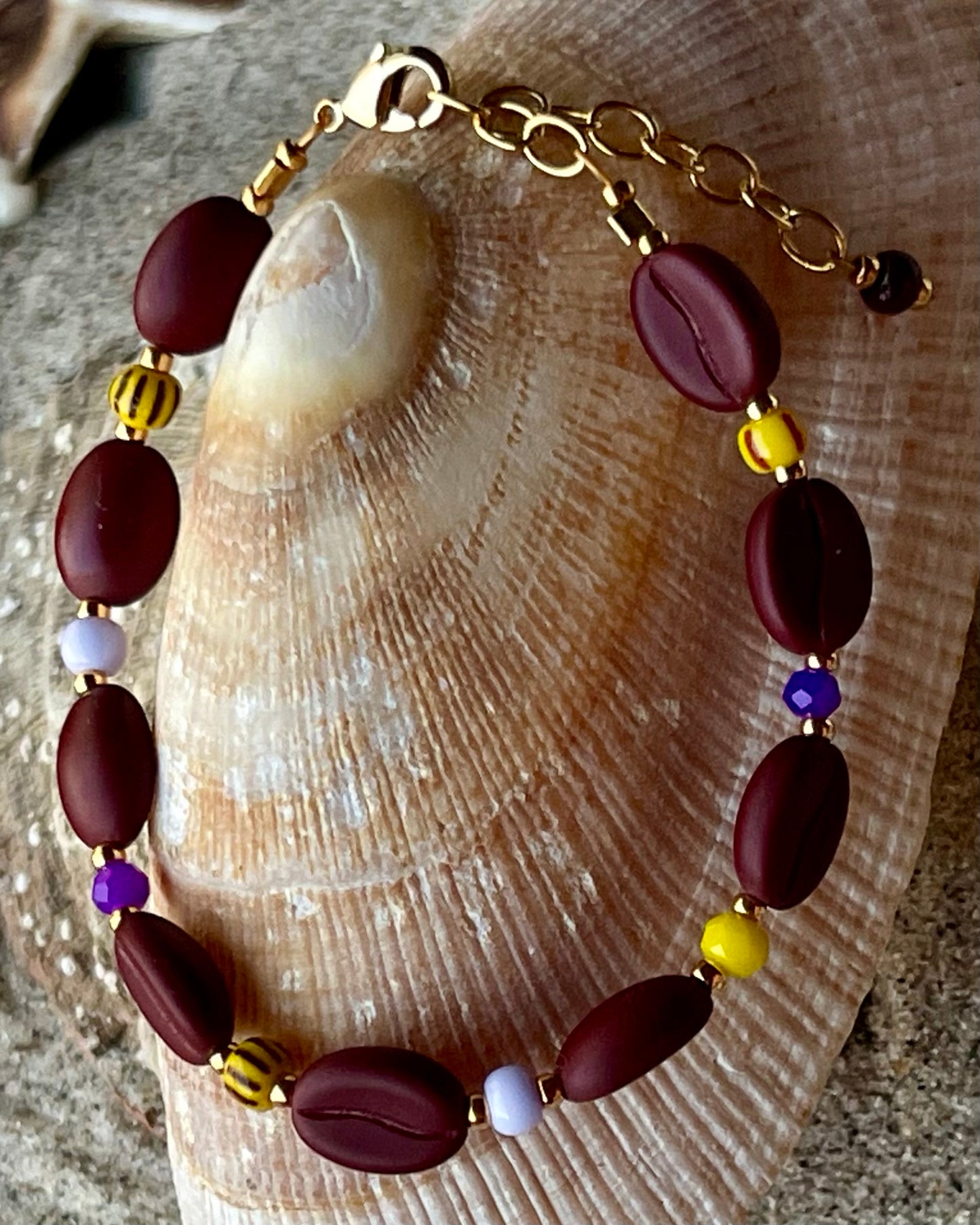 Kaffebønne-armbånd lavet med smukke brune glasperler, kombineret med seed beads og små glasperler i lækre gul og lilla nuancer, der giver et spændende og elegant look.