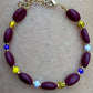 Kaffebønne-armbånd lavet med smukke brune glasperler, kombineret med seed beads og små glasperler i lækre gul og lilla nuancer, der giver et spændende og elegant look.