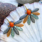 Speciel blomsterørering i blå nuancer med orange glasperle