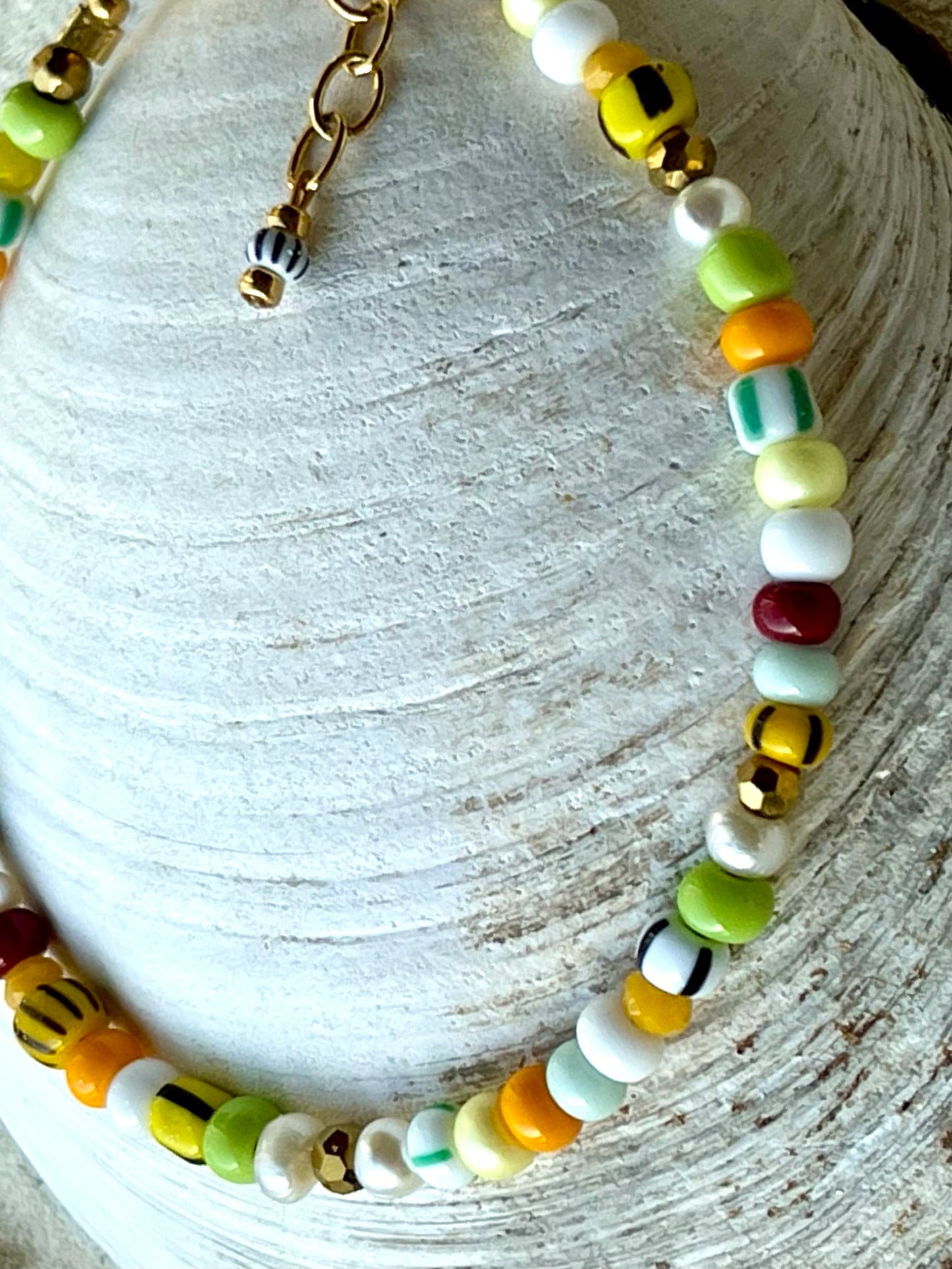 Armbånd med store Seed Beads i lækre gulegrønne, orange og brune nuancer og med små ferskvandsperler