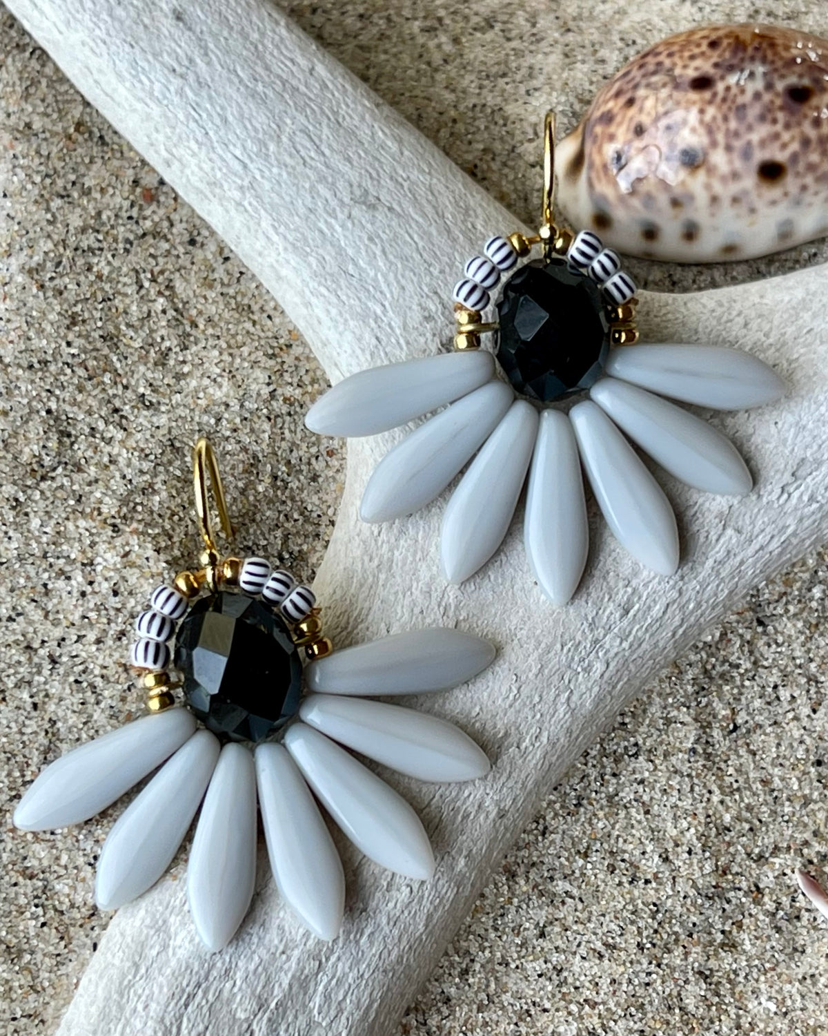 Stor blomsterørering med sort glasperle i midten og fine lysegrå glasperler som blade.