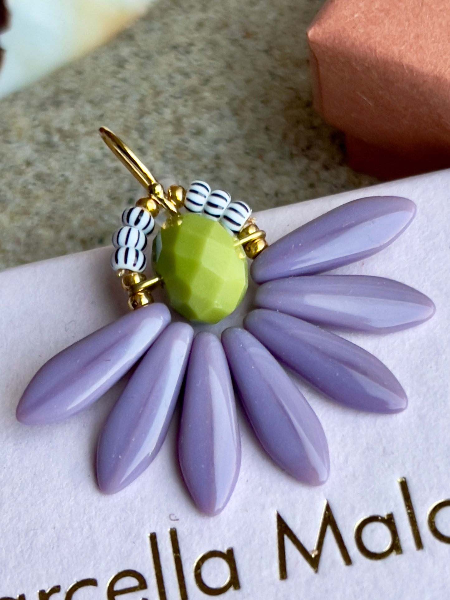 Stor blomster ørering med lys grøn glasperle i midten og med blade af flotte lyse lilla gladperler