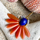Stor blomsterørering med blade af glasperler ibrændt orange og en flot koboltfarvet glasperle i midten.