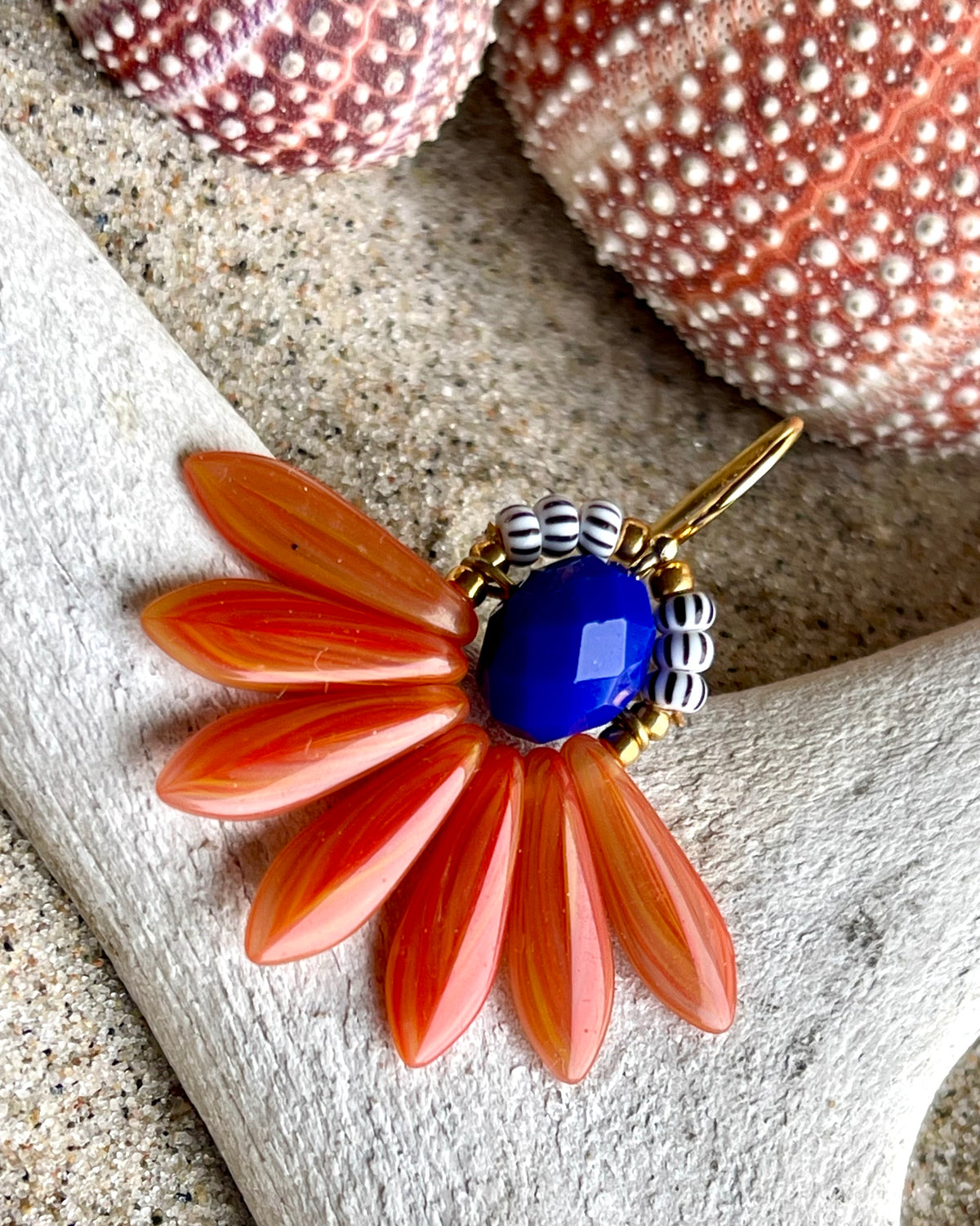 Stor blomsterørering med blade af glasperler ibrændt orange og en flot koboltfarvet glasperle i midten.
