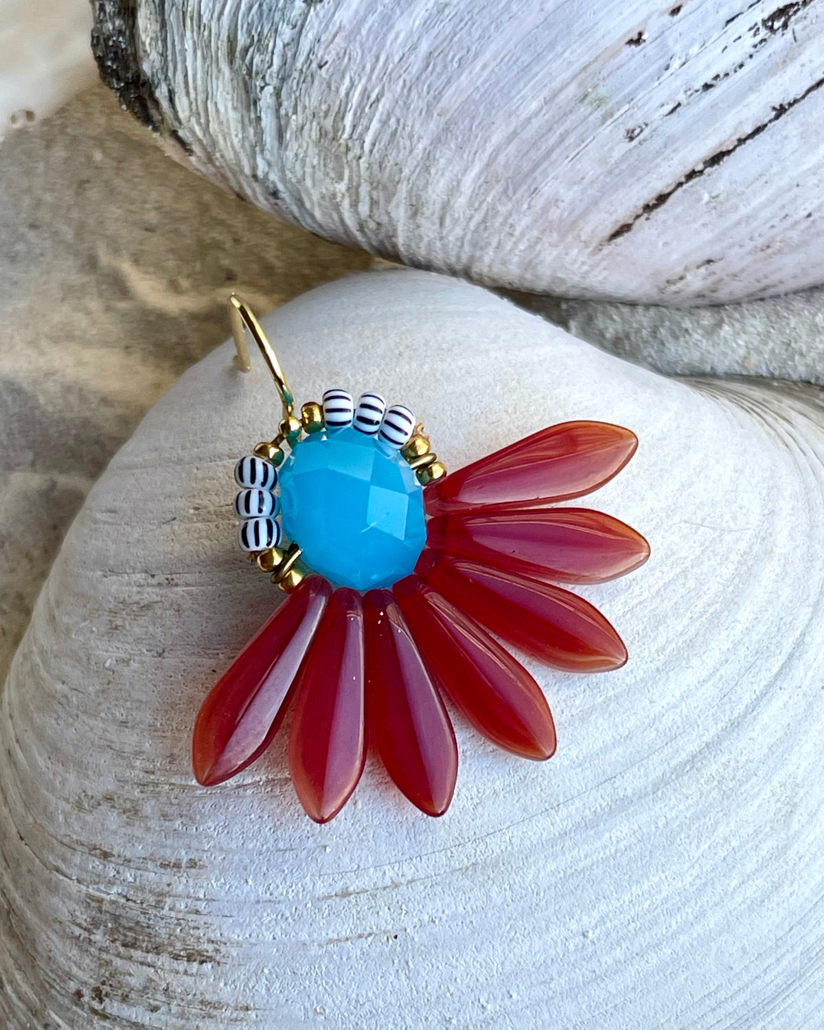 Stor blomsterørering med blade af hindbærrøde og azurblå glasperler.