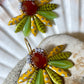 Meget speciel blomsterørering i gulgrønne nuancer med brun glasperle