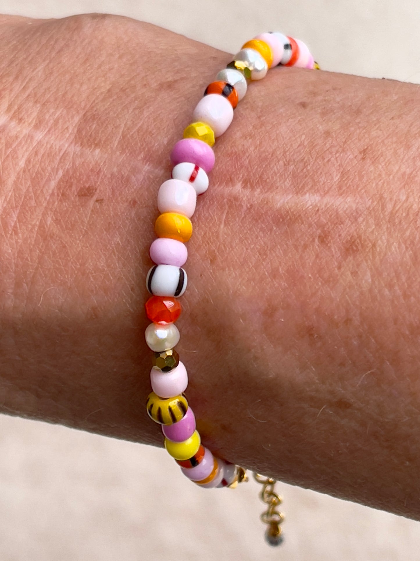 Armbånd med store Seed Beads i lækre rosa og orange farver og små ferskvandsperler
