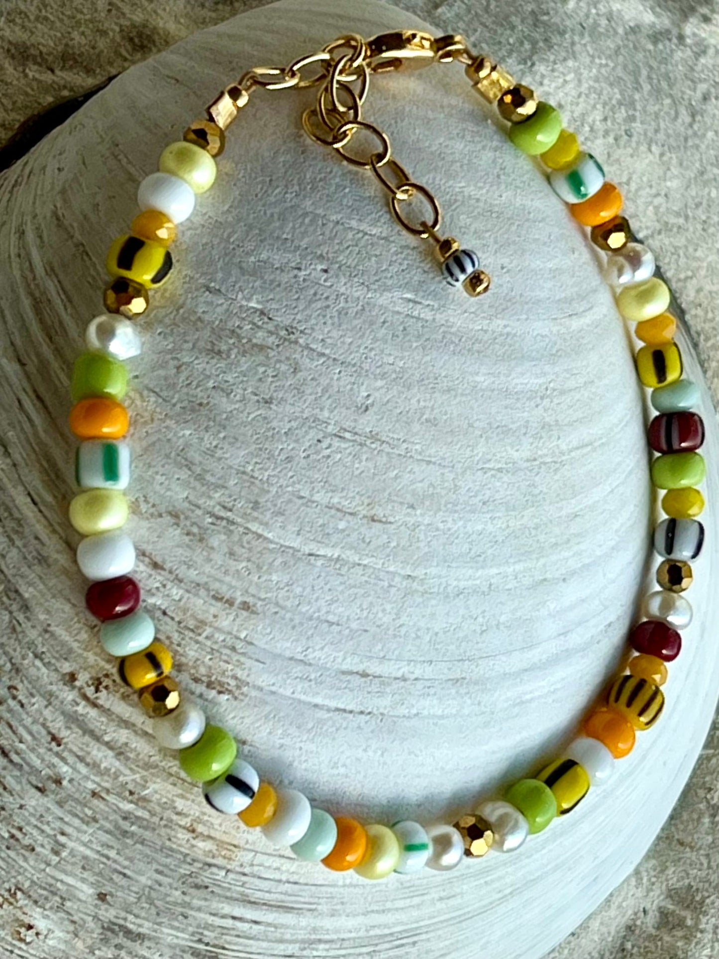 Armbånd med store Seed Beads i lækre gulegrønne, orange og brune nuancer og med små ferskvandsperler