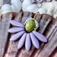 Stor blomster ørering med lys grøn glasperle i midten og med blade af flotte lyse lilla gladperler