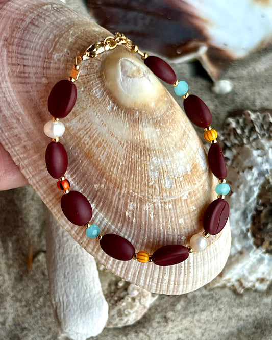 Kaffebønne-armbånd lavet med smukke brune glasperler, kombineret med seed beads og små glasperler i lækre lyseblå og orange nuancer, samt små ferskvandsperler der giver et elegant look.