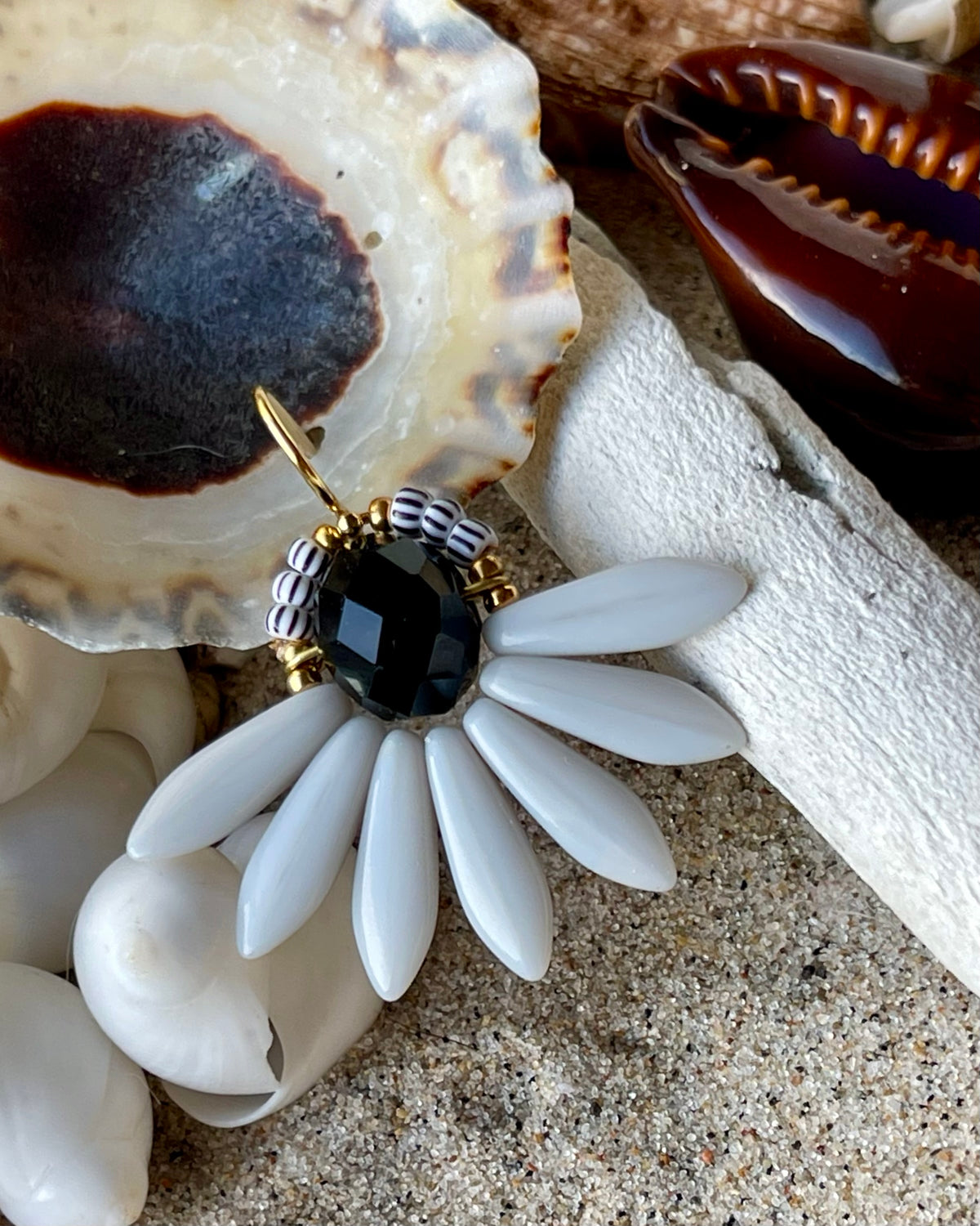 Stor blomsterørering med sort glasperle i midten og fine lysegrå glasperler som blade.