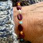 Kaffebønne-armbånd lavet med smukke brune glasperler, kombineret med seed beads og små glasperler i lækre lyseblå og orange nuancer, samt små ferskvandsperler der giver et elegant look.