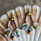 Hvid og multifarvet ørering med store og små seed beads i