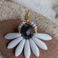 Stor blomsterørering med sort glasperle i midten og fine lysegrå glasperler som blade.